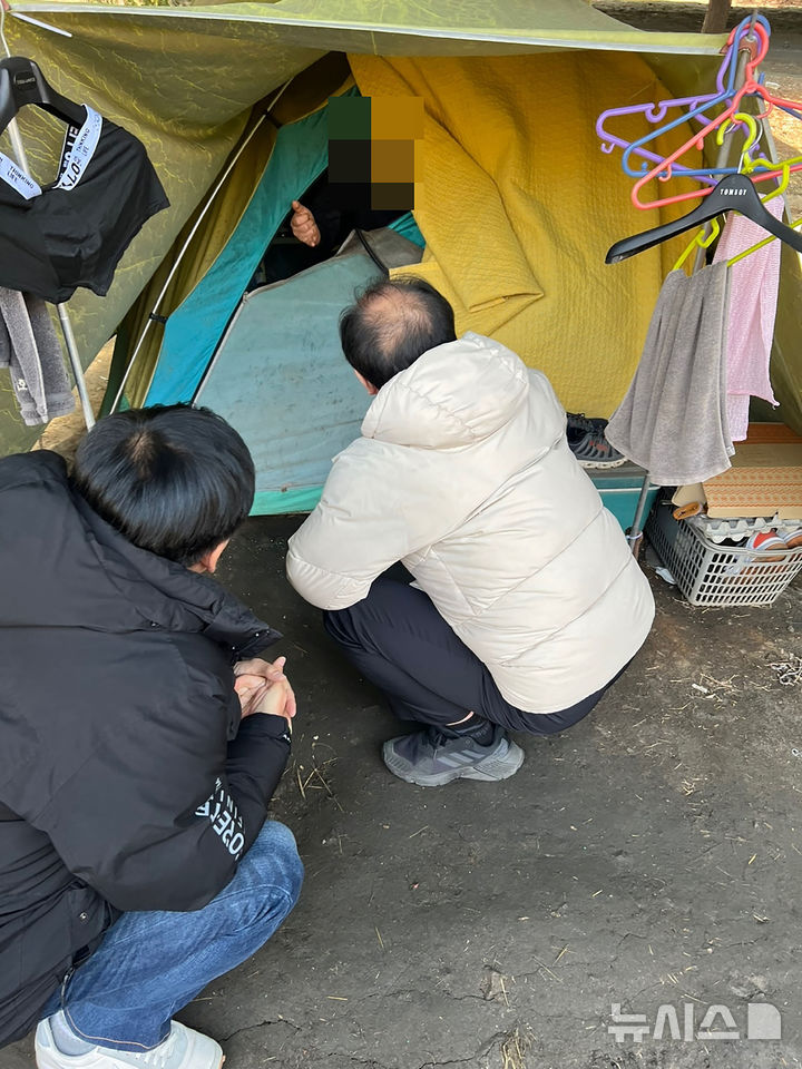 [성남=뉴시스] 성남시노숙인종합지원센터 종사자들이 모란역 인근에 텐트를 치고 생활 중인 노숙인을 지원하기 위해 대화를 시도 중이다 (사진=성남시 제공) 2025.04.10.photo@newsis.com