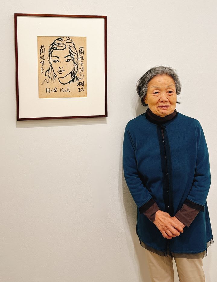 [사진=박현주 미술전문기자] 10일 성곡미술관에서 개인전을 연 석난희 화백이 스승인 김환기 화백이 그려준 자신의 그림 앞에서 소녀처럼 포즈를 취했다. 2025.04.10. hyun@newsis.com *재판매 및 DB 금지