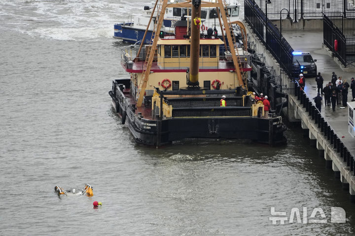 [뉴욕=AP/뉴시스] 10일(현지시간) 미국 뉴욕 허드슨 강 헬기 추락 현장에 바지선이 도착하고 있다. 2025.04.11.