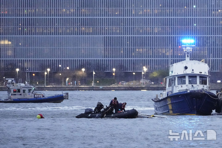 [저지시티=AP/뉴시스] 지난 10일(현지 시간) 미국 뉴저지주 저지시티에서 허드슨강에 추락한 헬기 사고 현장을 조사한 잠수사들이 물에서 나오고 있다. 2025.04.10.