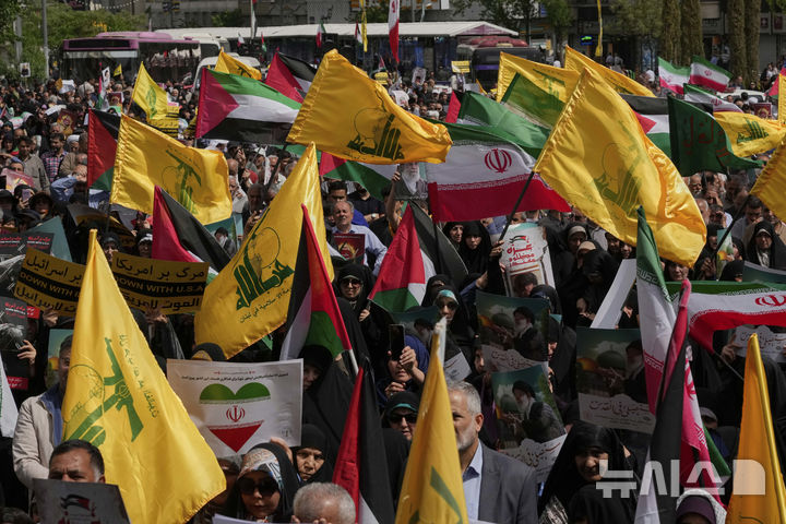 [테헤란=AP/뉴시스] 지난 4월 11일(현지 시간) 이란 수도 테헤란에서 시위대가 팔레스타인과 레바논 헤즈볼라 깃발을 흔들며 연대를 표하고 있다. 2025.08.26.