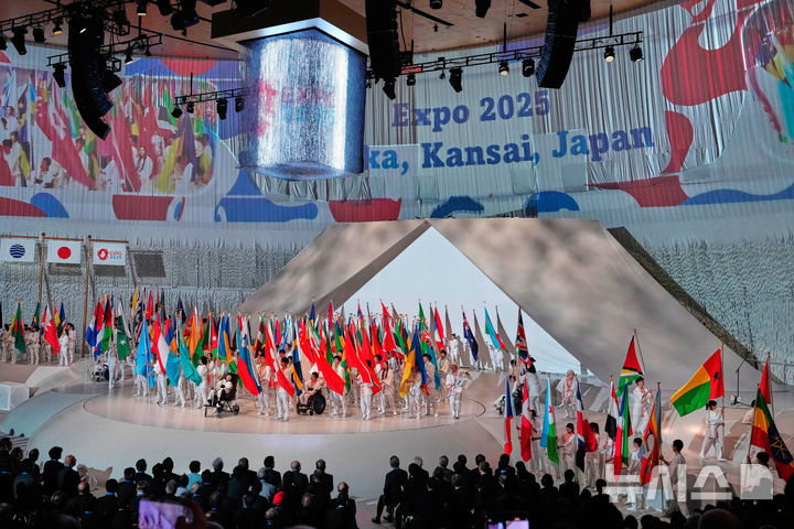 [오사카=AP/뉴시스] 12일 일본 오사카에서 열린오사카·간사이 엑스포 개회식에서 학생들이 참가 국가와 지역의 깃발을 들고 입장하고 있다. 2025.04.12.