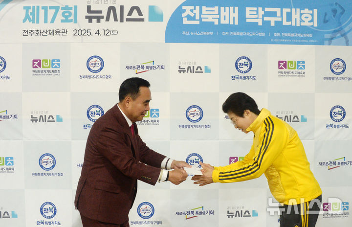 [전주=뉴시스] 김얼 기자 = 윤석일(왼쪽) 뉴시스 전북본부 본부장이 12일 전북 전주시 전주화산체육관에서 제17회 뉴시스 전북배 탁구대회를 열고 기념품을 전달하고 있다. 2025.04.12. pmkeul@newsis.com