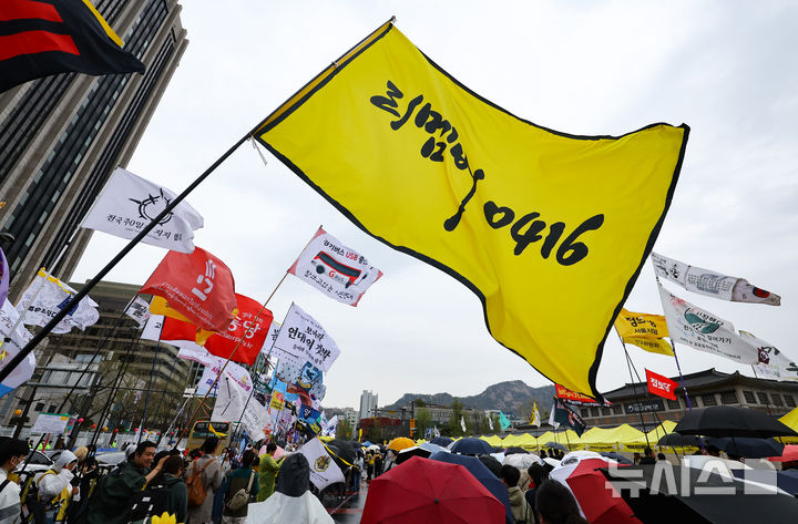 [서울=뉴시스] 황준선 기자 = 12일 오후 서울 종로구 경복궁 서십자각터에서 열린 세월호 참사 11주기 기억약속시민대회에서 참석자들이 깃발을 흔들고 있다. 2025.04.12. hwang@newsis.com