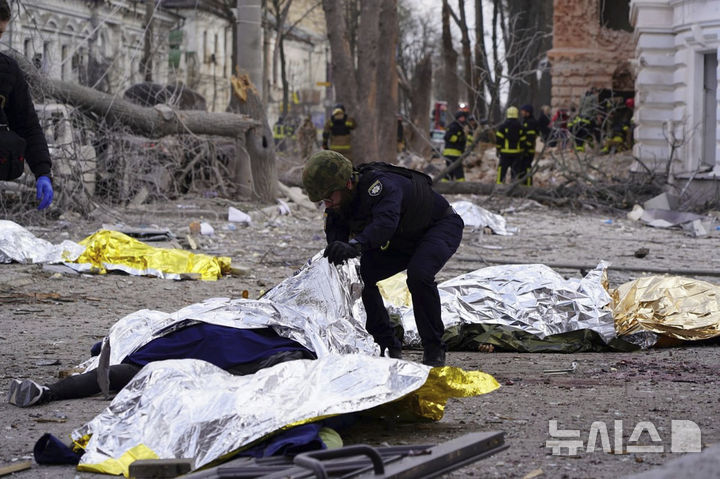 [수미=AP/뉴시스] 13일(현지 시간) 우크라이나 수미에서 한 경찰관이 러시아 미사일 공격으로 사망한 피해자를 조사하고 있다. 사진은 우크라이나 긴급서비스 제공. 2025.04.14.