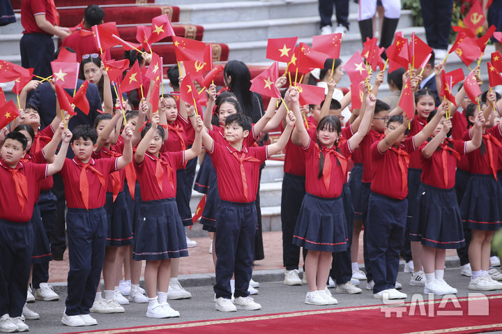 [하노이=AP/뉴시스] 14일(현지 시간) 베트남 하노이 대통령궁에서 열리는 시진핑 중국 국가주석 공식 환영식에 앞서 베트남 화동들이 양국 국기를 흔들고 있다. 2025.04.15.