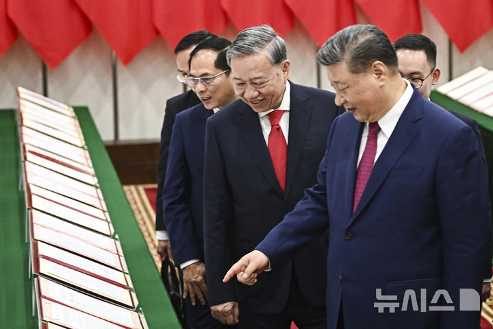 [하노이=AP/뉴시스] 시진핑(오른쪽) 중국 국가 주석이 14일(현지 시간) 베트남 하노이의 당 중앙위원회 청사에서 또 럼 베트남 공산당 서기장과 회담을 마친 후 함께 양국 간 체결했던 협정서 사본을 들러보고 있다. 2025.04.15.