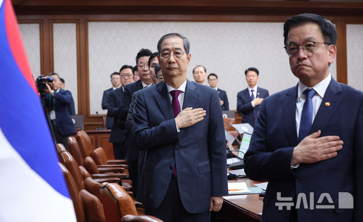 [서울=뉴시스] 조수정 기자 = 한덕수 대통령 권한대행 국무총리가 14일 정부서울청사에서 열린 국무회의에서 국기에 경례하고 있다. 오른쪽은 최상목 경제부총리 겸 기획재정부 장관. 2025.04.14. chocrystal@newsis.com