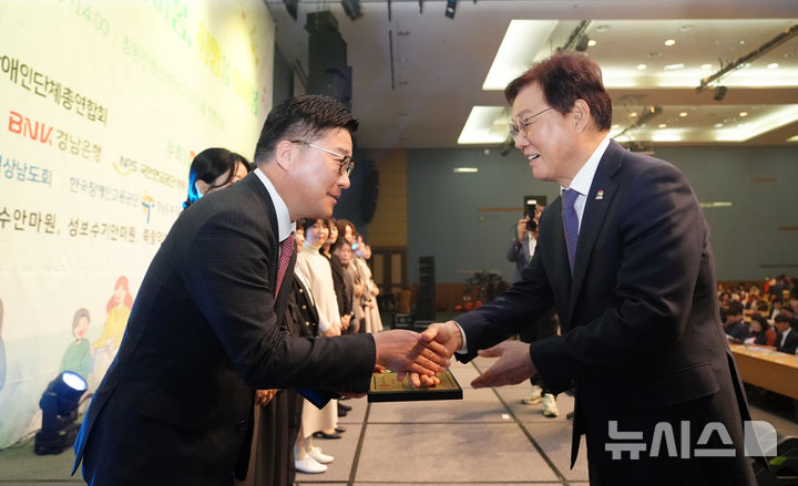 [창원=뉴시스] BNK경남은행 허종구 부행장(왼쪽)이 15일 창원컨벤션센터에서 열린 제45회 장애인의 날 기념 포상식에서 박완수 도지사로부터 도지사 표창을 받고 있다. (사진=BNK경남은행 제공) 2025.04.15. photo@newsis.com
