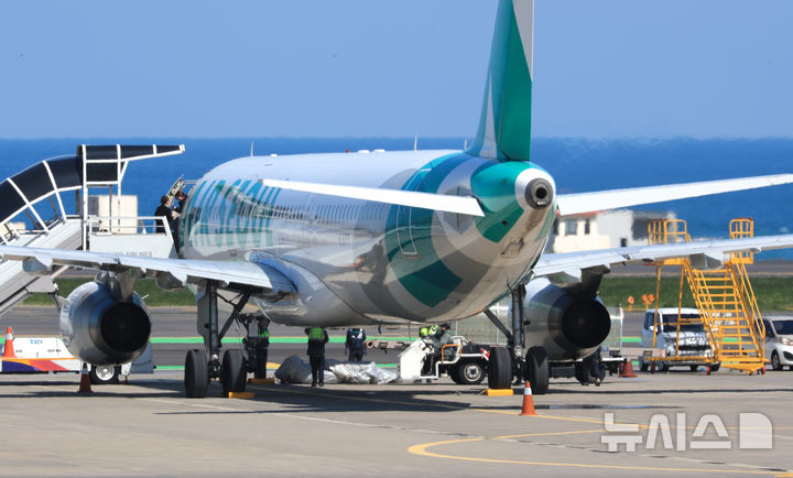 [제주=뉴시스] 우장호 기자 = 15일 오전 8시15분께 제주공항 활주로에서 승객이 비상문을 열어 비상탈출용 슬라이드가 펼쳐저 항공기가 이륙을 포기하는 사고가 발생했다. 비상탈출 슬라이드가 개방되자 기동 불능상태가 된 항공기는 멈춰 섰고, 한국공항공사는 견인차로 이 항공기를 주기장으로 옮겼다. 이날 오전 주기장으로 옮겨진 에어서울 RS902편 모습. 2025.04.15. woo1223@newsis.com