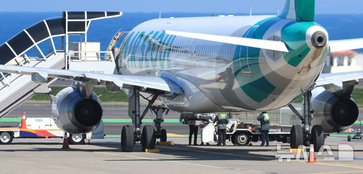 [제주=뉴시스] 우장호 기자 = 15일 오전 8시15분께 제주공항 활주로 이륙 준비를 하던 에어서울 RS902편 안에서 폐소공포증을 호소한 승객이 비상문을 열어 비상탈출용 슬라이드가 펼쳐저 항공기가 이륙을 포기하는 사고가 발생했다. 비상탈출 슬라이드가 개방되자 기동 불능상태가 된 항공기는 멈춰 섰고, 한국공항공사는 견인차로 이 항공기를 주기장으로 옮겼다. 제주공항 관계자들이 에어서울 RS902편에서 개방된 비상탈출용 슬라이드를 정리하고 있다. 2025.04.15. woo1223@newsis.com