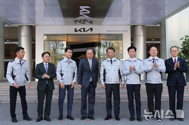 [광주=뉴시스] 조수정 기자 = 한덕수 대통령 권한대행 국무총리가 15일 자동차산업 현장방문차 광주 서구 기아오토랜드 광주공장을 찾아 기념촬영을 마친 뒤 대화하며 내부로 이동하고 있다. 왼쪽부터 김희준 현대차·기아 상무, 강기정 광주광역시장, 김동욱 현대차·기아 부사장, 한 권한대행, 최준영 기아 사장, 이항수 현대차·기아 부사장, 문재웅 기아 광주공장장(전무), 이승렬 산업통상자원부 산업정책실장.2025.04.15. chocrystal@newsis.com