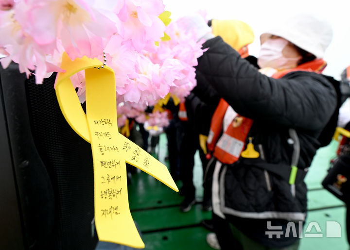 [진도=뉴시스] 김혜인 기자 = 세월호 참사 11주기를 맞은 16일 오전 전남 진도군 맹골수도에서 열린 선상추모식에 앞서 0416단원고가족협의회 세월호 유족이 희생자를 기리는 노란리본을 달고 있다. 2025.04.16. hyein0342@newsis.com