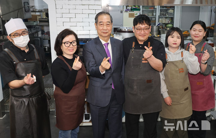 [울산=뉴시스] 최진석 기자 = 한덕수 대통령 권한대행 국무총리가 16일 울산 뚠뚠이 돈가스를 방문해 결식 아동들에게 무료 점심을 제공해온 사장 및 직원들과 기념촬영하고 있다. (대통령실통신사진기자단) 2025.04.16. myjs@newsis.com