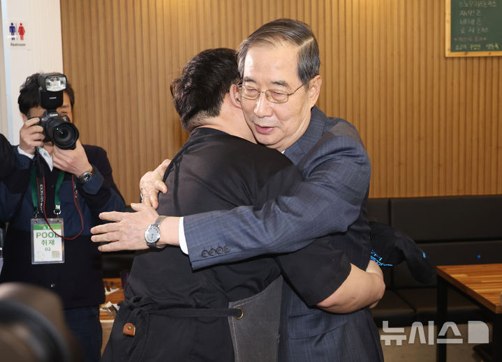 [울산=뉴시스] 최진석 기자 = 한덕수 대통령 권한대행 국무총리가 16일 울산 뚠뚠이 돈가스를 방문해 결식 아동들에게 무료 점심을 제공해온 사장과 포옹하고 있다. (대통령실통신사진기자단) 2025.04.16. myjs@newsis.com