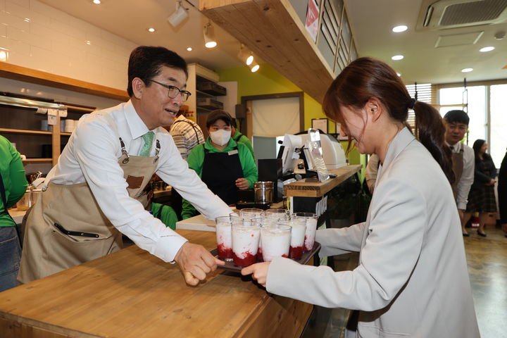 17일 충북도교육청 '어울림 카페'에서 1일 점장에 나선 윤건영 충북교육감(왼쪽)이 음료를 건네주고 있다. 2025.04.17.kipoi@newsis.com *재판매 및 DB 금지