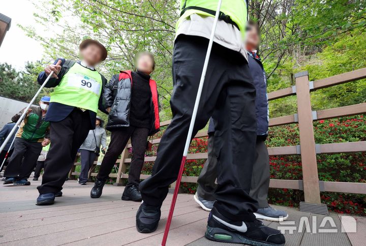 [부산=뉴시스] 하경민 기자 = 제45주년 장애인의 날(4월20일)을 앞두고 17일 부산 북구 구포무장애숲길에서 열린 '무장애숲길 걷기대회'에 참가한 시각장애인들이 자원봉사원의 도움을 받아 숲길을 걷고 있다.&nbsp; 이날 행사에는 지역 시각장애인 100명과 자원봉사원, 구청 직원 등 250여 명이 참가했다. 2025.04.17. yulnetphoto@newsis.com