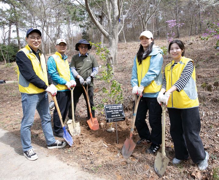[서울=뉴시스] 동서식품이 지난 17일 충청남도 태안군에 위치한 천리포수목원에서 생물다양성 보전을 위한 임직원 봉사활동을 진행했다. 봉사활동에 참여한 동서식품 임직원들이 나무를 심고 있다. (사진=동서식품) 2025.04.18. photo@newsis.com *재판매 및 DB 금지