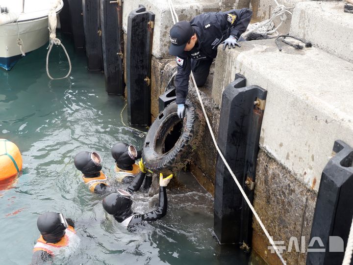 [제주=뉴시스] 제주지방해양경찰청과 민간 다이버 등이 18일 오후 제주 서귀포시 가파도에서 열린 합동 해양 환경 정화 활동에서 수중에 있는 폐타이어를 건져 올리고 있다. (사진=제주지방해양경찰청 제공) 2025.04.18. photo@newsis.com