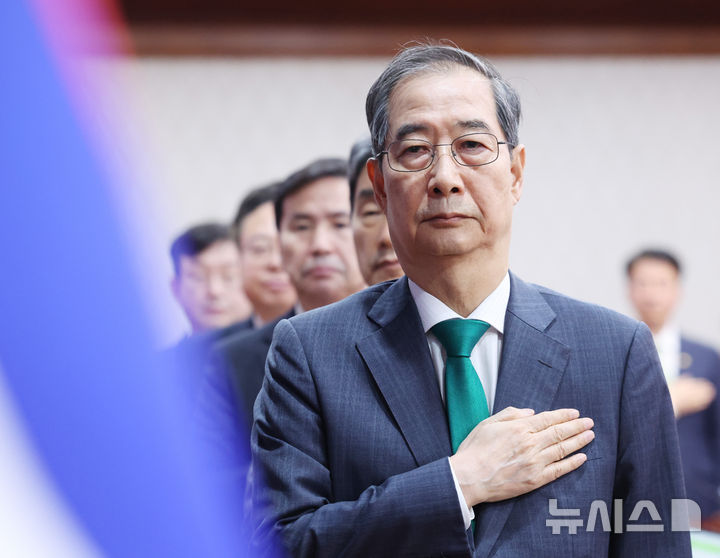 [서울=뉴시스] 조수정 기자 = 한덕수 대통령 권한대행 국무총리가 18일 정부서울청사에서 추가경정예산안 심의 임시국무회의에서 국기에 경례하고 있다. 2025.04.18. chocrystal@newsis.com