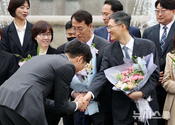 [서울=뉴시스] 김명년 기자 = 문형배 헌법재판소장 권한대행과 이미선 헌법재판관이 18일 오전 서울 종로구 헌법재판소에서 열린 퇴임식 기념촬영에서 꽃다발을 전달받고 있다. 2025.04.18. kmn@newsis.com