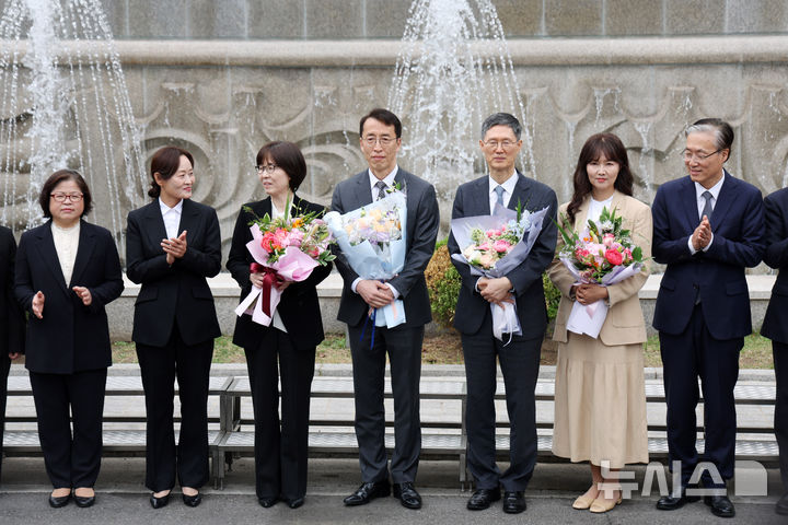 [서울=뉴시스] 김명년 기자 = 문형배 헌법재판소장 권한대행과 이미선 헌법재판관이 18일 오전 서울 종로구 헌법재판소에서 열린 퇴임식 후 기념촬영에서 재판관들에게 축하를 받고 있다. 2025.04.18. kmn@newsis.com