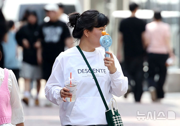 [대구=뉴시스] 이무열 기자 = 대구 낮 최고기온이 29도까지 오르며 초여름 날씨를 보인 18일 대구 중구 동성로에서 한 시민이 손 선풍기를 들고 길을 걷고 있다. 2025.04.18. lmy@newsis.com