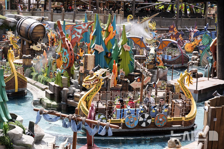 [올랜도( 미 플로리다주)=AP/뉴시스]올랜도 유니버설 리조트의 에픽 유니버스 테마 파크에 있는 "용 길들이기" 코너에서 사람들이 용 장식이 붙은 보트를 타며 즐기고 있다. 2025. 09.19. 