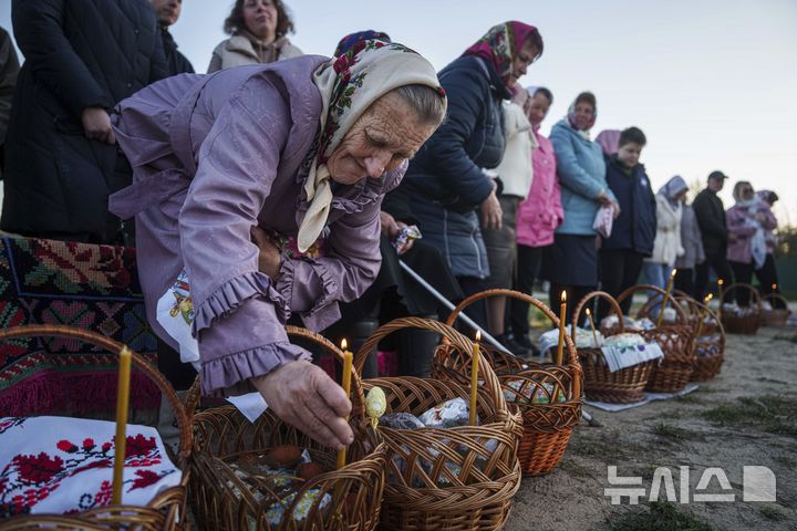 [크라스네=AP/뉴시스] 20일(현지 시간) 우크라이나 크라스네 마을에서 열린 정교회 부활절 행사 중 한 할머니가 축복받을 부활절 바구니를 준비하고 있다. 2025.04.21.