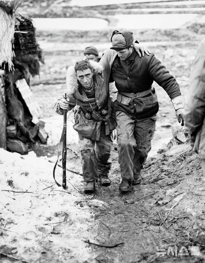 [서울=뉴시스]국가보훈부는 6·25전쟁에 참전해 대한민국을 지키기 위해 목숨을 걸고 싸웠던 고 윌리엄 크라이슬러 캐나다 참전용사의 유해봉환식이 오는 21일 인천국제공항에서 거행된다고 20일 밝혔다. 사진은 가평전투 직후 부상당한 동료를 부축하여 이동하는 크라이슬러(사진 오른쪽) 참전용사. (사진=주한 캐나다대사관 제공) 2025.04.20 