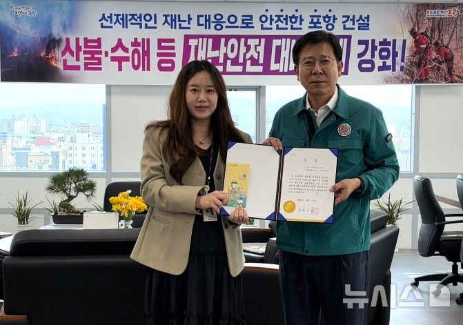 [포항=뉴시스] 송종욱 기자 = 포항시는 지난 17일 3월 민원 처리 단축 마일리지제 우수 공무원으로 최현주 북구청 복지환경위생과 주무관을 선발했다. 사진은 최 주무관에게 김응수(오른쪽) 북구청장이 우수 공무원 상장을 전달하며 격려하는 모습. (사진=포항시 제공) 2025.04.20. photo@newsis.com
