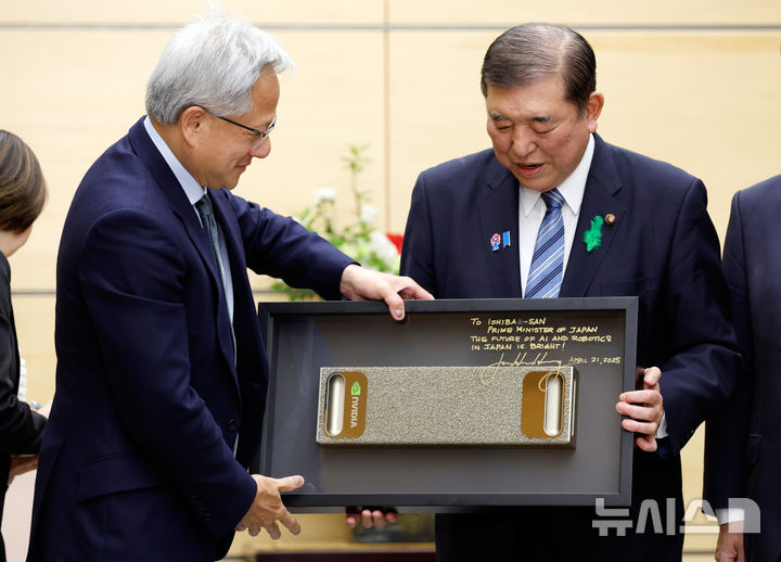 [도쿄=AP/뉴시스] 이시바 시게루(오른쪽) 일본 총리가 21일 일본 도쿄 총리 관저에서 젠슨 황 엔비디아 최고경영자(CEO)로부터 회담 전 선물을 받고 있다. 2025.04.21.