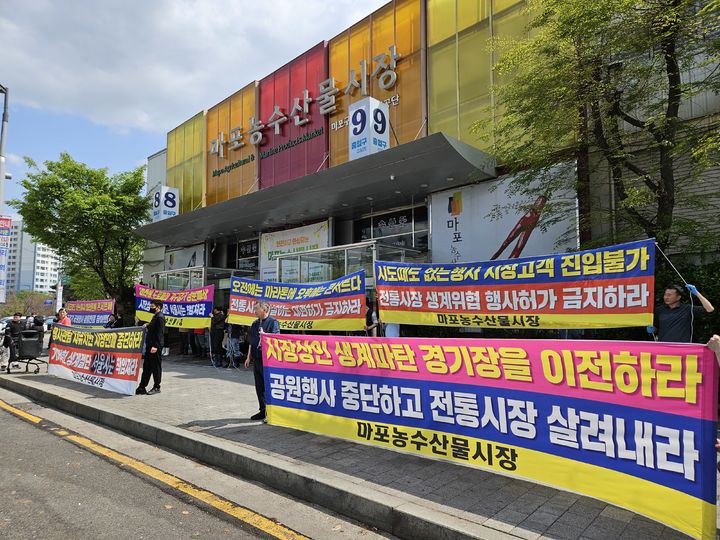 [서울=뉴시스] 이태성 기자 = 서울 마포농수산물시장 상인 50여명은 21일 오후 2시께 성산동 시장 정문에서 기자회견을 열고 "인근 월드컵경기장, 평화의공원 등에서 열리는 대관 행사로 피해가 발생하고 있다"고 주장했다. 2025.04.21. victory@newsis.com *재판매 및 DB 금지
