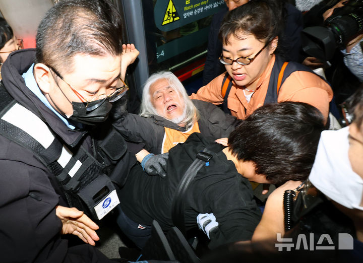 [서울=뉴시스] 박주성 기자 = 전국장애인차별철폐연대(전장연)의 출근길 지하철 탑승 시위가 1년여 만에 재개된 21일 서울 지하철 4호선 혜화역에서 전장연 회원이 지하철 탑승을시도하다 서울교통공사 관계자와 충돌하고 있다. 2025.04.21. park7691@newsis.com