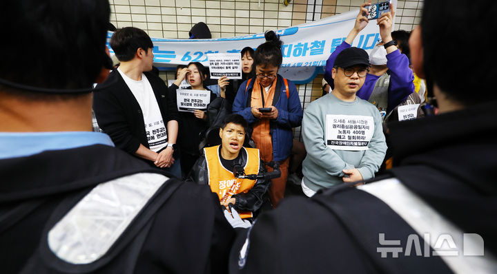 [서울=뉴시스] 박주성 기자 = 전국장애인차별철폐연대(전장연)의 출근길 지하철 탑승 시위가 1년여 만에 재개된 21일 서울 지하철 4호선 혜화역에서 전장연 회원들이 시위를 하고 있다. 2025.04.21. park7691@newsis.com