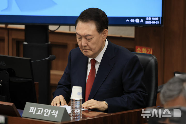 [서울=뉴시스] 사진공동취재단 = 12·3 비상계엄을 선포해 내란 우두머리 혐의로 재판에 넘겨진 윤석열 전 대통령이 21일 오전 서울 서초구 서울중앙지법 417호 법정에 앉아 재판 시작을 기다리고 있다. 2025.04.21. photo@newsis.com
