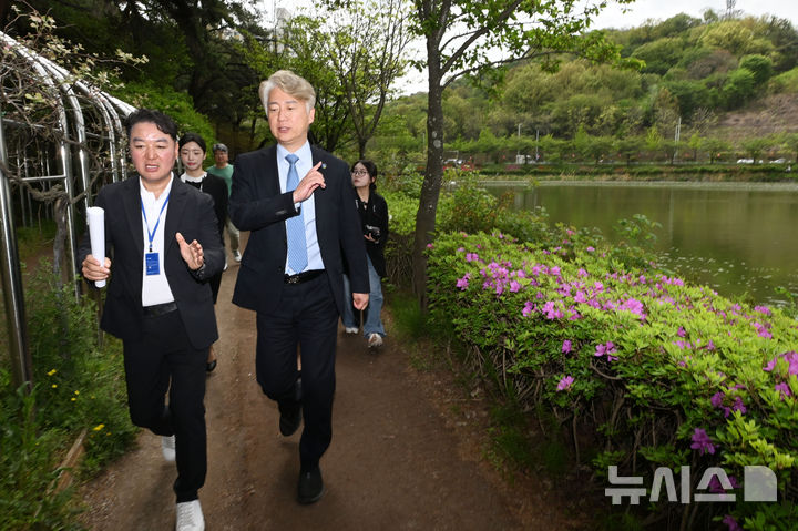 [광주=뉴시스] 이영주 기자 = 김이강(오른쪽) 광주 서구청장과 김희철 빛고을중앙공원개발㈜ 사업총괄본부장이 21일 오전 광주 서구 풍암호수공원을 돌며 중앙공원1지구 사업 계획 이야기를 나누고 있다. 2025.04.21. leeyj2578@newsis.com