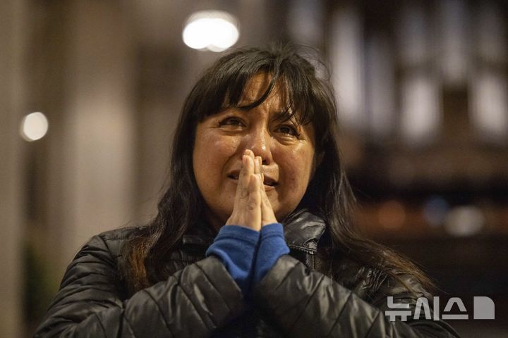 [뉴욕=AP/뉴시스] 21일(현지 시간) 미국 뉴욕의 성 패트릭 대성당에서 한 신도가 프란치스코 교황의 사진 앞에서 흐느끼며 기도하고 있다. 2025.04.22.