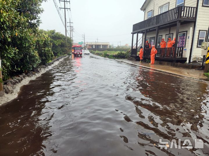 [제주=뉴시스] 강풍을 동반한 많은 비가 내리고 있는 22일 오전 제주 서귀포시 성산읍의 한 도로가 침수돼 소방당국이 배수 지원에 나서고 있다. (사진=제주소방안전본부 제공) 2025.04.22. photo@newsis.com 