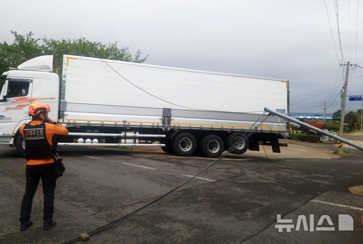 [제주=뉴시스] 강풍을 동반한 많은 비가 내리고 있는 22일 오전 제주시 애월읍에서 강풍에 전신주가 쓰러져 소방당국이 안전조치에 나서고 있다. (사진=제주소방안전본부 제공) 2025.04.22. photo@newsis.com 