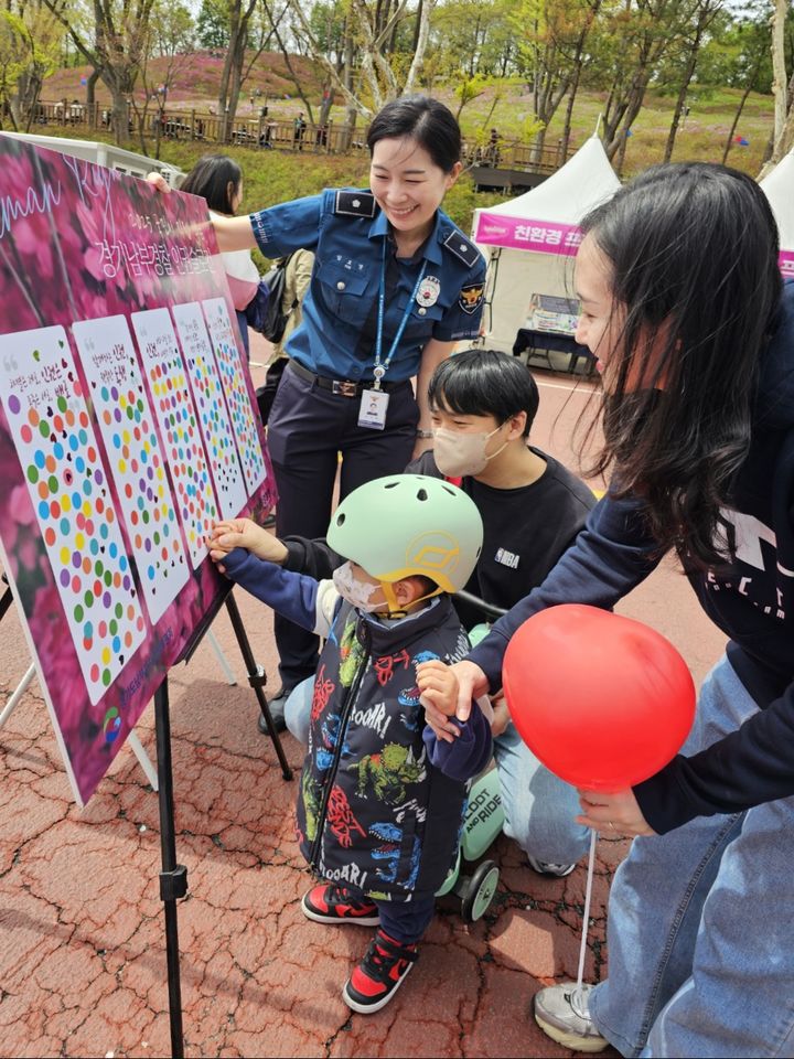 [수원=뉴시스] 군포 철쭉 축제에 방문한 시민들이 올해 '경기남부경찰 인권슬로건 공모전'에 투표하고 있는 모습. (사진=경기남부경찰청 제공) 2025.04.23. photo@newsis.com *재판매 및 DB 금지
