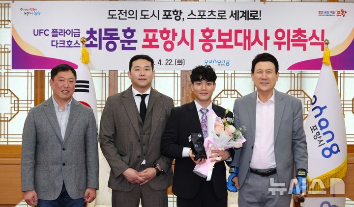 [포항=뉴시스] 송종욱 기자 = 포항시가 세계적인 종합 격투기 무대 UFC 플라이급 최동훈 선수를 홍보대사로 위촉했다. 사진은 정원석(왼쪽부터) 시의회 자치행정위원장, 김인수 포항팀매드 관장, 최 선수, 이 시장이 기념 촬영하는 모습. (사진=포항시 제공) 2025.04.22. photo@newsis.com 