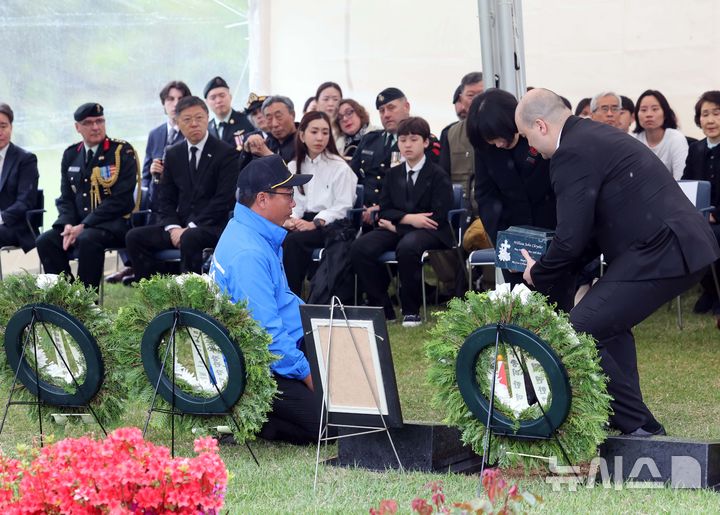 [부산=뉴시스] 하경민 기자 = 캐나다 한국전 참전용사 고(故) 윌리엄 존 크라이슬러씨의 안장식이 열린 22일 부산 남구 유엔기념공원 참전용사묘역에서 유가족이 유해함을 안장하고 있다. 유엔기념공원에는 고인을 포함해 총 14개국 2331명의 한국전 유엔군 참전용사가 잠들어 있다. 2025.04.22. yulnetphoto@newsis.com