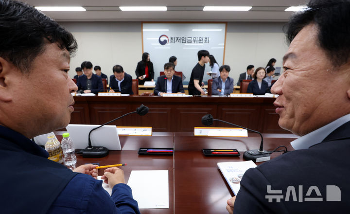 [세종=뉴시스] 강종민 기자 = 22일 세종시 정부세종청사에서 열린 최저임금위원회 제1차 전원회의에서 류기정 사용자 위원(오른쪽)과 류기섭 근로자 위원이 대화하며 미소 짓고 있다. 2025.04.22. ppkjm@newsis.com