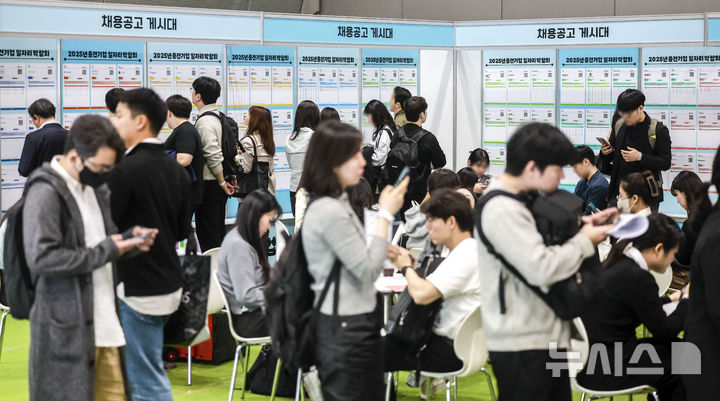 [서울=뉴시스] 정병혁 기자 = 23일 서울 강남구 코엑스에서 열린 2025년 중견기업 일자리 박람회를 찾은 구직자들이 채용정보 게시판을 살펴보며 채용 상담을 기다리고 있다. 2025.04.23. jhope@newsis.com