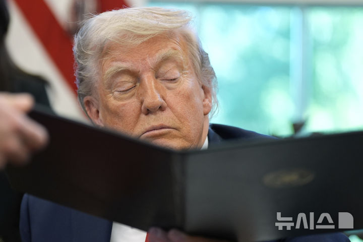 [워싱턴=AP/뉴시스]도널드 트럼프 미 대통령이 23일(현지시각) 자신이 서명한 행정명령문을 윌 샤프 백악관 비서에게 넘겨주고 있다. 2025.4.24. 