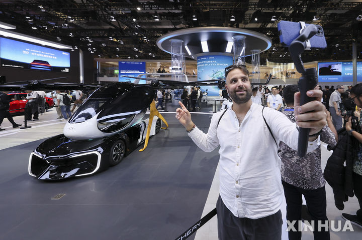 [상하이=신화/뉴시스] 23일 개막한 21회 상하이모터쇼에서 한 남성 관람객이 체리의 플라잉카를 실시간 동영상으로 소개하고 있다. 2025.04.24.