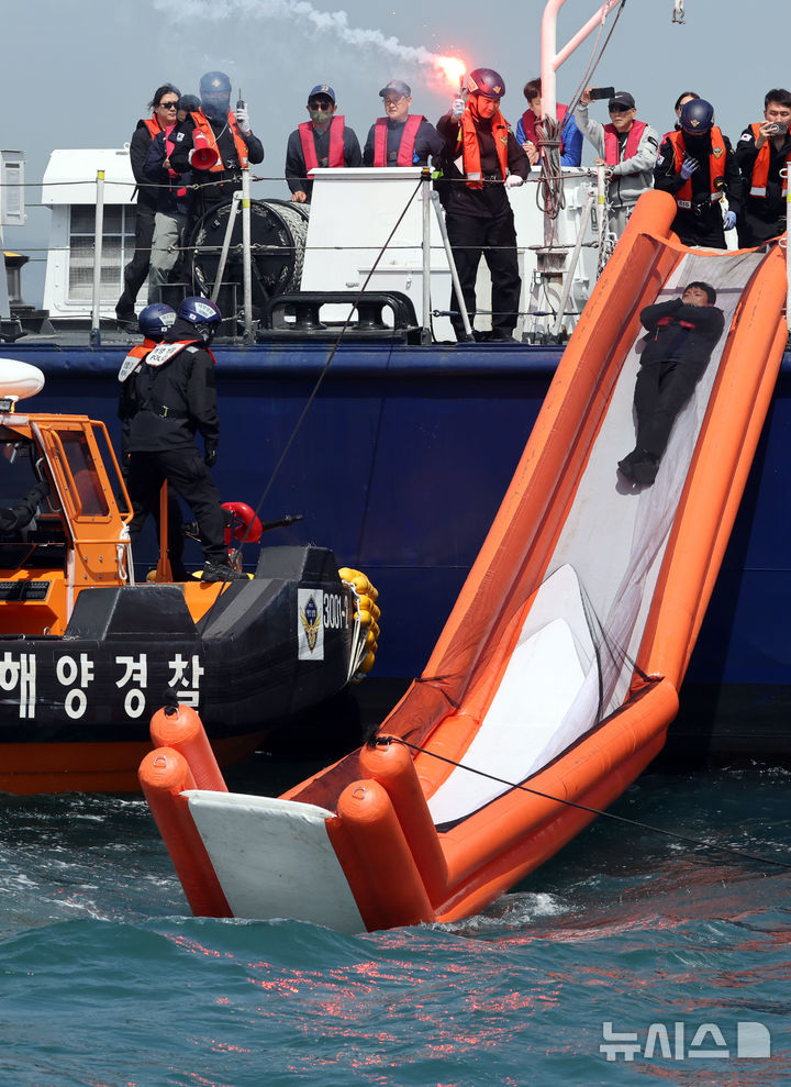 [부산=뉴시스] 하경민 기자 = 항공기 해상 불시착 상황을 가정한 수난대비 합동 구조훈련이 열린 24일 부산 강서구 진우도 인근 해상에 불시착한 모의항공기(500t급 경비함)에서 해경이 비상탈출하는 승객들을 구조하고 있다. 이날 훈련에는 남해지방해양경찰청, 창원해양경찰서 등 13개 유관기관·단체에서 총 14척의 선박과 헬기 1기가 동원됐다. 2025.04.24. yulnetphoto@newsis.com