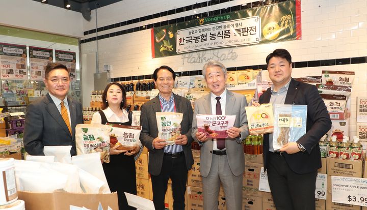 [세종=뉴시스] 강호동 농협중앙회장(왼쪽 4번째)이 H마트 뉴저지주 리지필드점에서 열린 '한국농협 농식품 특판전'에서 H마트 관계자들과 함께 농협의 가공식품을 들고 기념촬영을 하고 있는 모습. (사진=농협 제공) 2025.04.25. photo@newsis.com  *재판매 및 DB 금지