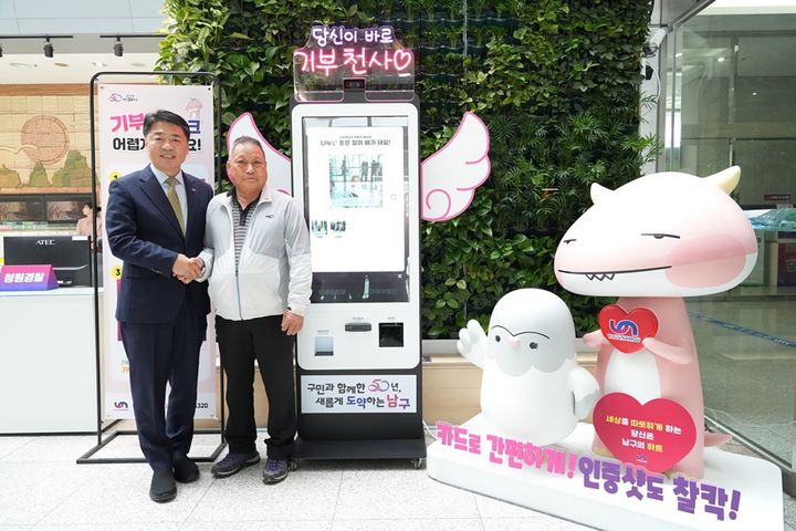 [부산=뉴시스] 25일 부산 남구청 2층 민원실에 설치된 기부 키오스크의 1호 기부천사인 구민 노맹옥(오른쪽)씨가 오은택 남구청장과 기념 사진을 촬영하고 있다. (사진=부산 남구청 제공) 2025.04.25. photo@newsis.com *재판매 및 DB 금지